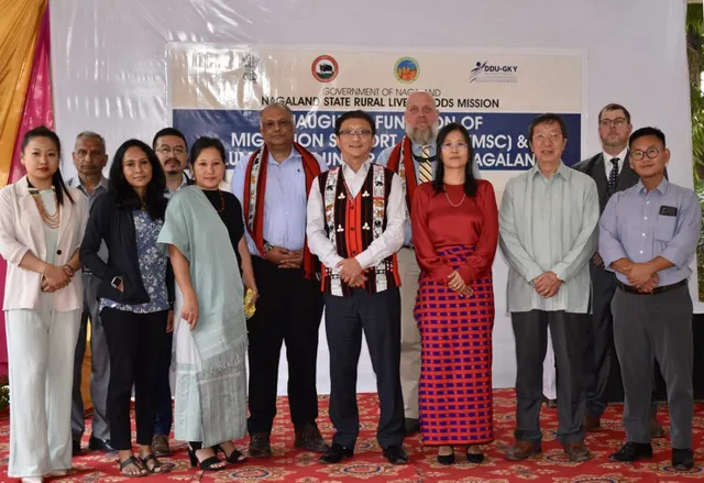Officials and guests standing in a row in front of a Nagaland State Rural Livelihoods Mission event banner