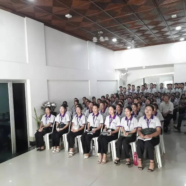 Rows of trainees in uniform seated in a hall during a skilling programme